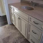 Full guest bathroom featuring uniquely colored linen cabinets with a coffee glaze
